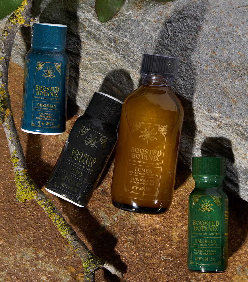 Four bottles of Boosted Botanix products on a stone surface